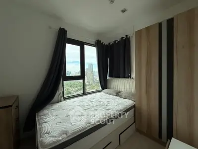 Modern bedroom with large window offering stunning city view, featuring a comfortable bed and sleek wardrobe.