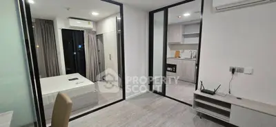Modern apartment interior with bedroom and kitchen, featuring sleek design and neutral tones.