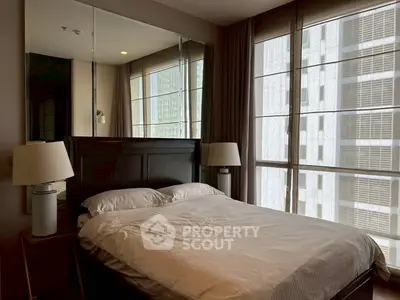 Luxurious bedroom with large windows and elegant decor in a modern apartment.