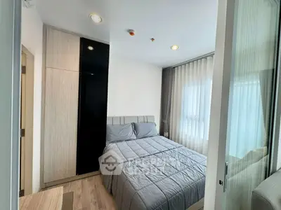 Cozy modern bedroom with stylish decor and ample natural light.