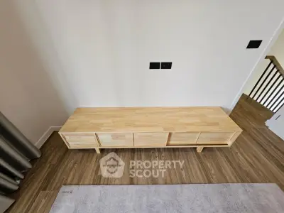 Modern wooden console table in stylish living room with hardwood floors and neutral decor.