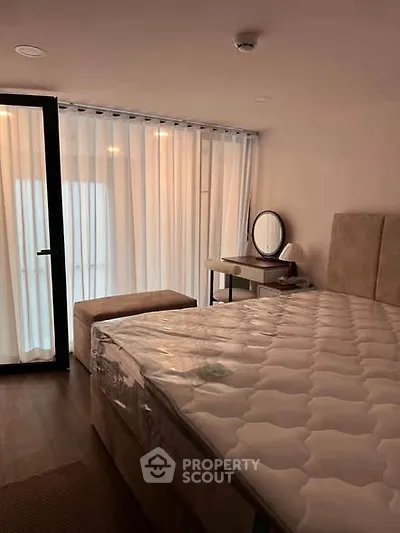 Modern bedroom with large window and elegant furnishings in a stylish apartment.