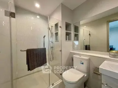 Modern bathroom with glass shower enclosure and sleek fixtures