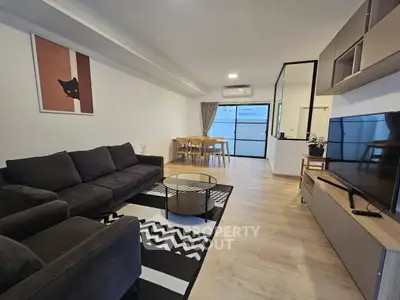 Modern living room with stylish decor and open layout, featuring a cozy sofa and sleek furniture.