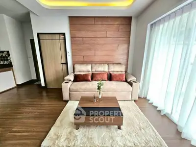 Modern living room with stylish sofa and wooden accents, featuring a cozy ambiance and natural light.