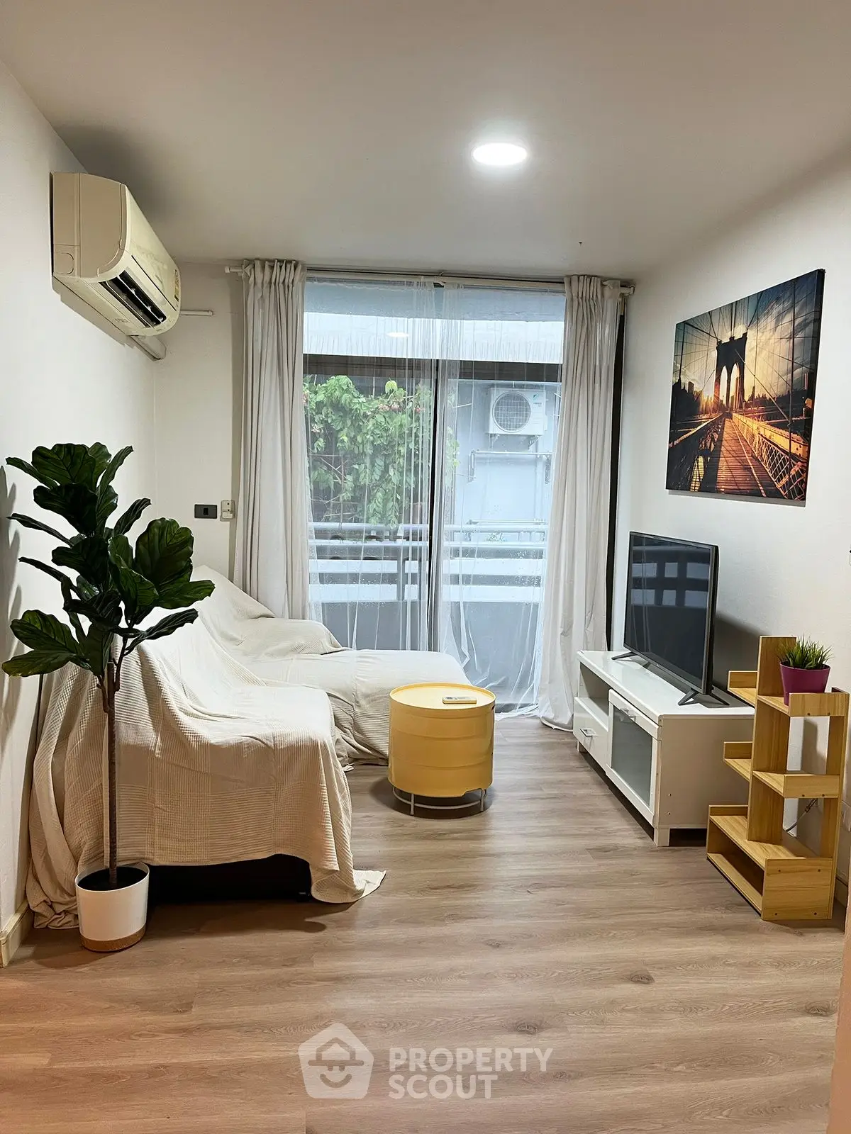 Cozy living room with modern decor and balcony view, perfect for relaxation.