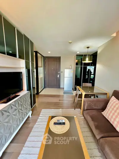 Modern living room with stylish decor and open layout, featuring a cozy sofa and sleek TV stand.