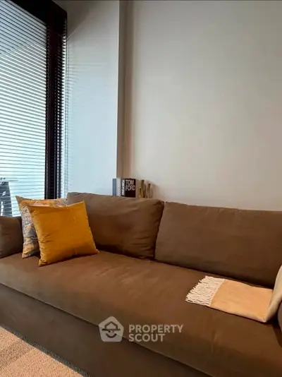 Stylish living room with modern brown sofa and decorative pillows, perfect for cozy relaxation.