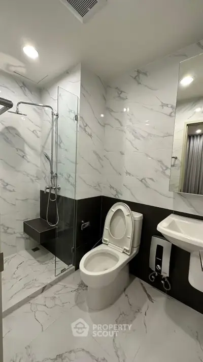 Modern bathroom with marble tiles and glass shower enclosure