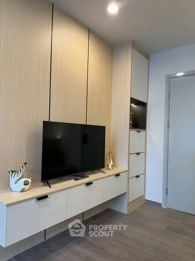 Modern living room with sleek TV unit and elegant decor in a stylish apartment.