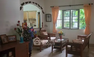 Charming living room with cozy seating and floral decor, perfect for relaxation and entertaining.