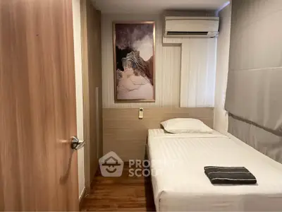 Cozy bedroom with single bed, modern decor, and air conditioning unit.