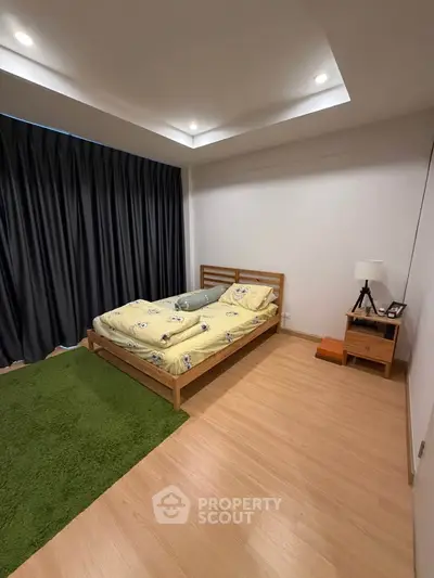 Cozy bedroom with wooden flooring and modern lighting