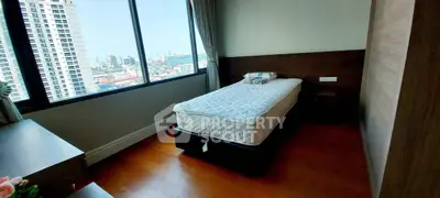 Modern bedroom with city view and single bed in high-rise apartment