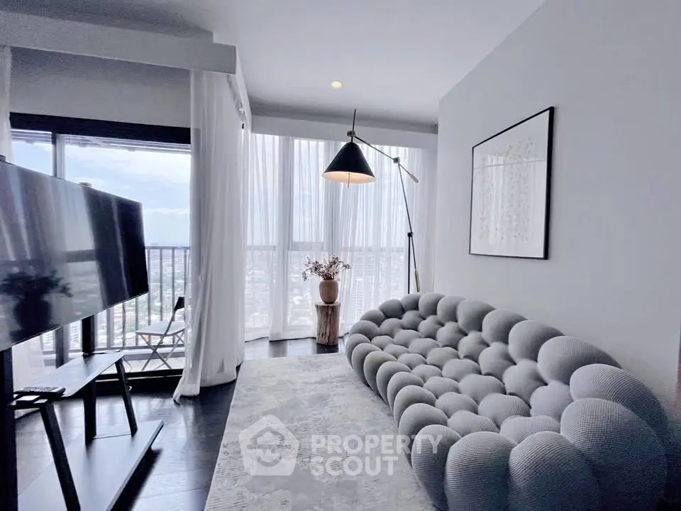 Modern living room with panoramic city view, stylish sofa, and floor-to-ceiling windows.