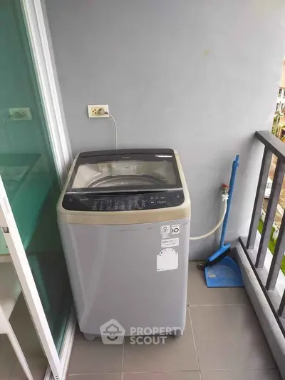 Modern washing machine on a balcony with a city view, perfect for urban living convenience.
