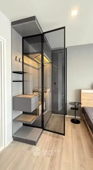 Modern bedroom with sleek glass wardrobe and minimalist design