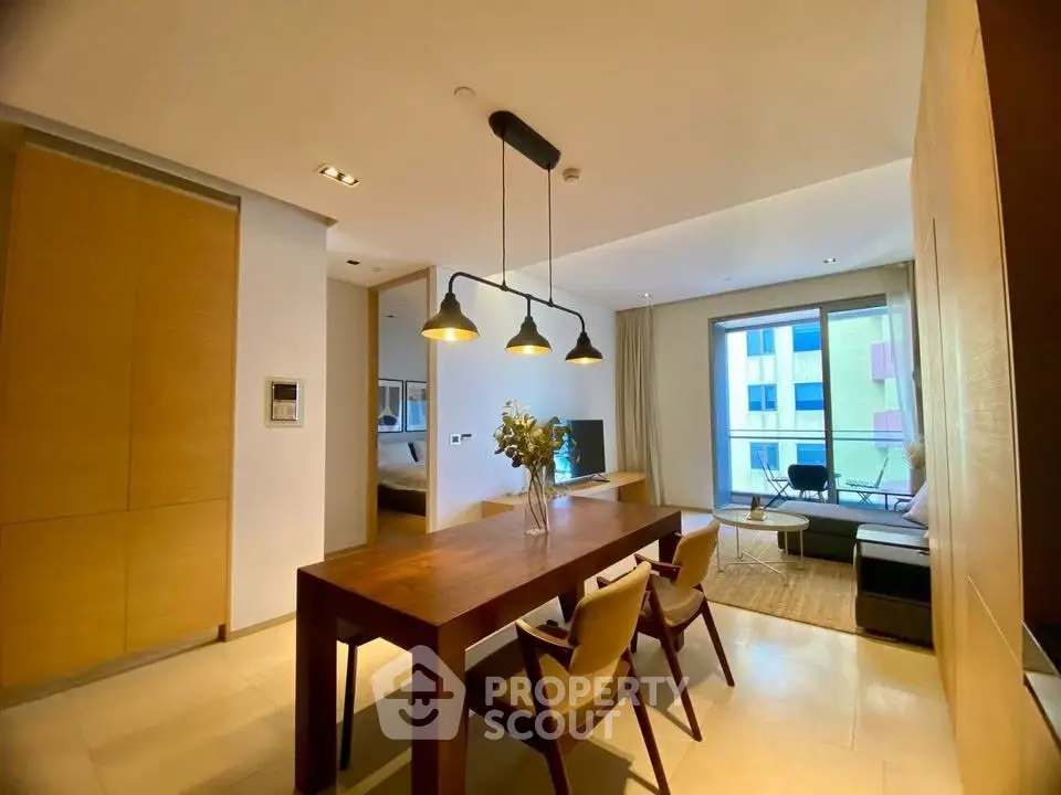Modern living room with dining area and large windows in a stylish apartment.