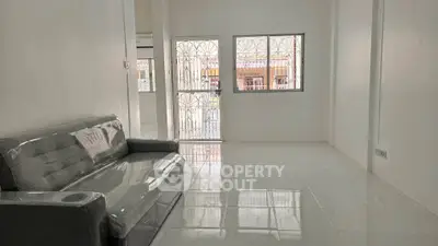 Spacious living room with modern sofa and large windows offering natural light.