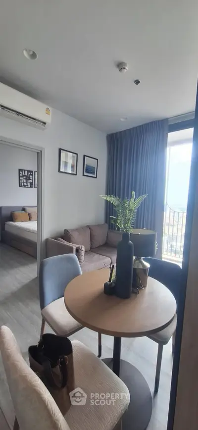 Modern living room with cozy seating and dining area, featuring stylish decor and natural light.