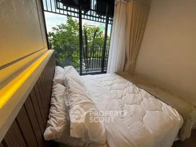 Cozy bedroom with a view of lush greenery from the balcony, featuring a comfortable bed and elegant curtains.
