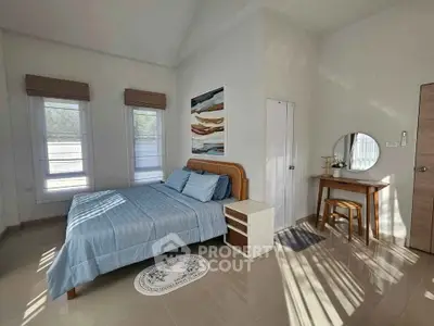 Spacious bedroom with modern decor and natural light, featuring a cozy bed and stylish furniture.