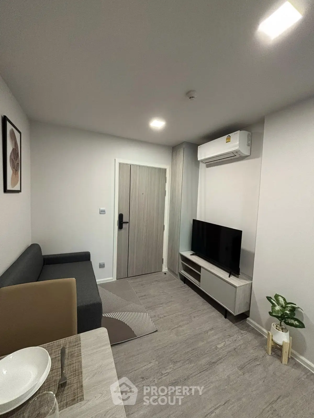 Modern living room with sleek furniture and air conditioning in a cozy apartment.