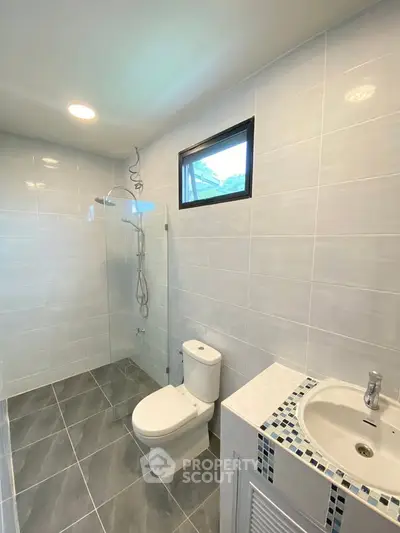 Modern bathroom with sleek tiles and glass shower enclosure