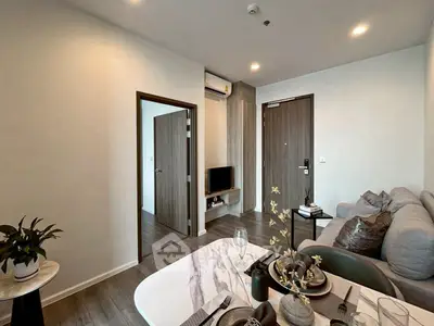 Modern living room with stylish decor and open layout, featuring a cozy sofa and elegant dining area.