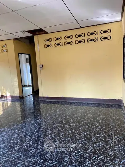 Spacious room with tiled flooring and natural light, ideal for versatile use.