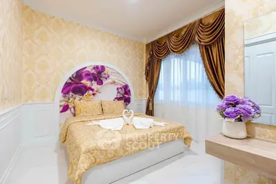 Luxurious bedroom with elegant decor and floral accents, featuring a cozy bed and stylish curtains.