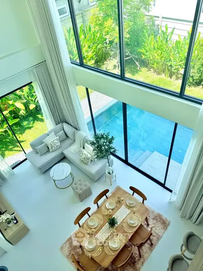 Luxurious open-plan living room with pool view and elegant dining area, perfect for entertaining.