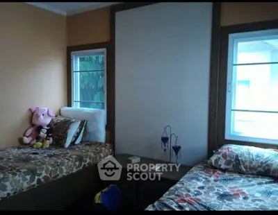 Cozy bedroom with twin beds and plush toys, perfect for a child's room.