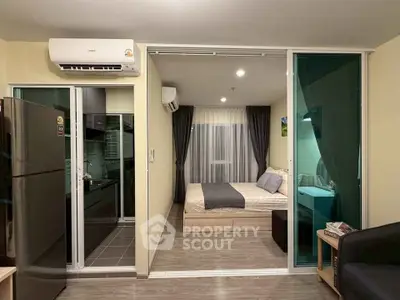 Modern studio apartment with sleek design, featuring a cozy bedroom and compact kitchen area.