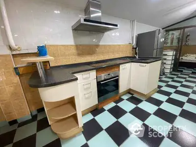 Spacious kitchen with modern appliances and unique checkered flooring