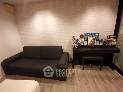 Cozy living room with dark sofa and decorative piano against brick wall