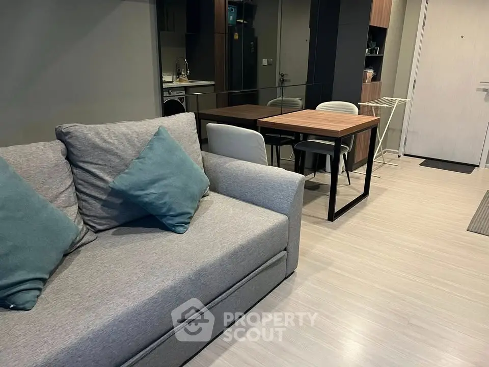 Modern living room with stylish furniture and open kitchen layout in a contemporary apartment.