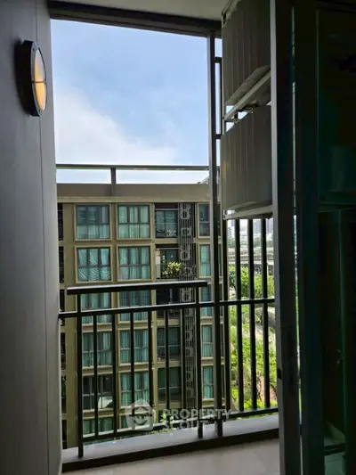 Modern apartment balcony with city view and sleek railing design.