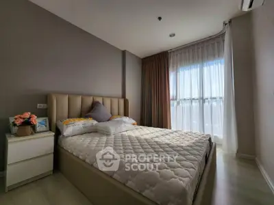 Cozy bedroom with large window and modern decor in a stylish apartment.