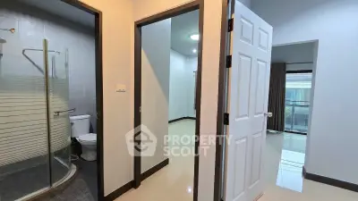 Modern apartment interior with bathroom and open hallway, showcasing sleek design and natural light.