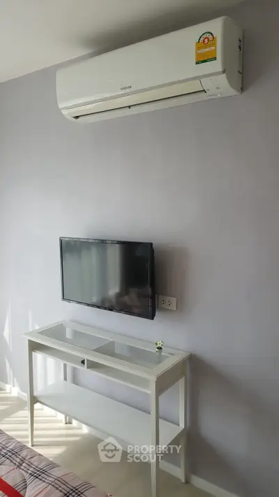 Modern living room with wall-mounted TV and air conditioning unit