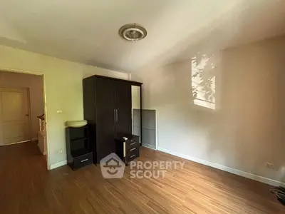 Spacious empty room with wooden flooring and wardrobe, ideal for customization.