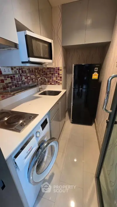 Modern compact kitchen with appliances including washing machine and fridge