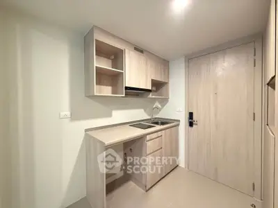 Modern compact kitchen with sleek cabinetry and built-in appliances in a minimalist design.