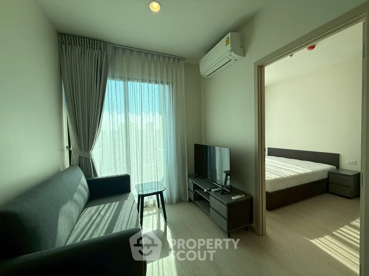 Modern apartment living room with natural light and cozy furnishings