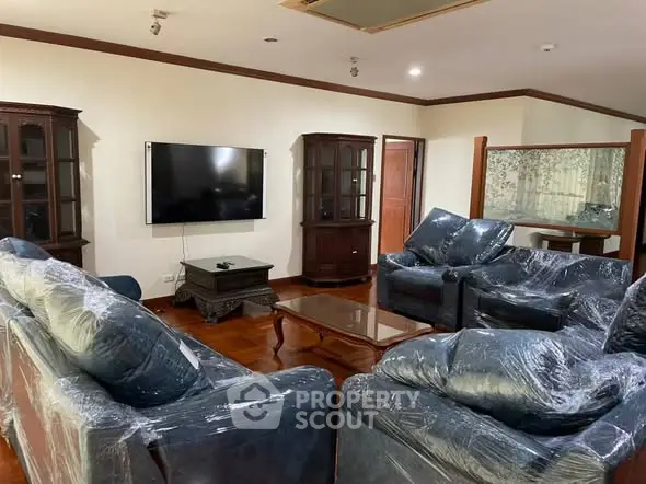Spacious living room with elegant furniture and wall-mounted TV, perfect for relaxation and entertainment.