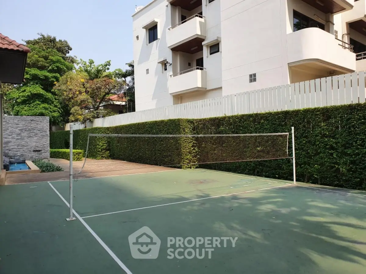 Spacious outdoor badminton court in modern residential complex with lush greenery