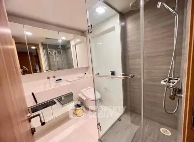 Modern bathroom with glass shower and sleek fixtures in a contemporary apartment.