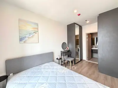 Modern bedroom with stylish decor and ensuite bathroom in a contemporary apartment.