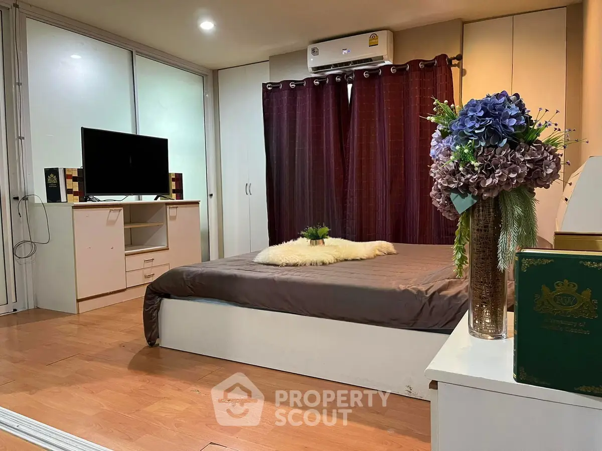 Cozy bedroom with modern decor, featuring a comfortable bed, stylish curtains, and a sleek TV setup.
